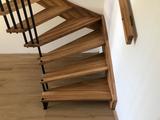 Dřevěné samonosné schodiště s železnými tyčkami v zábradlí