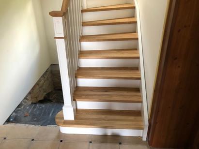 Dřevěné schodiště s atypickým bílým zábradlí,  