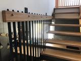 Dřevěné samonosné schodiště s železnými tyčkami v zábradlí